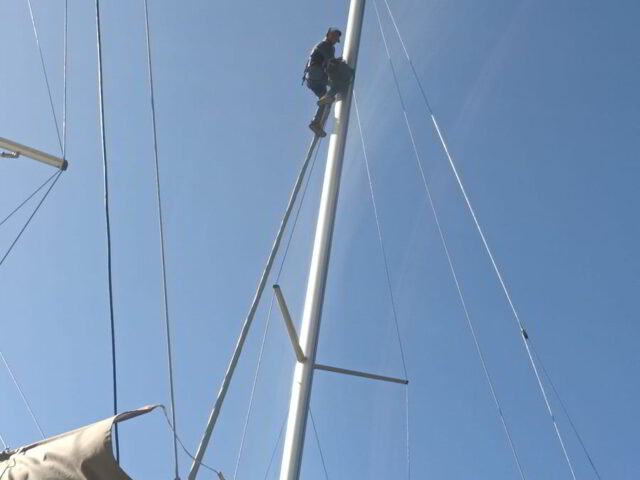 Tecnico YachtSitter al lavoro sull'albero di uno yacht durante servizio di rigging in Costa Smeralda